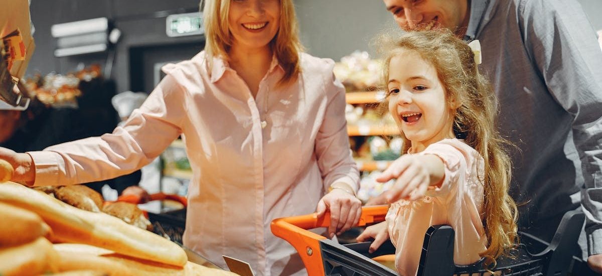 Happy family with a child shopping in a supermarket, smiling and bonding.