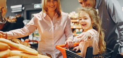 Happy family with a child shopping in a supermarket, smiling and bonding.