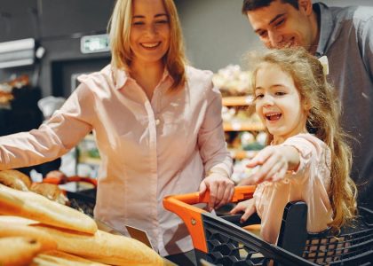 Happy family with a child shopping in a supermarket, smiling and bonding.