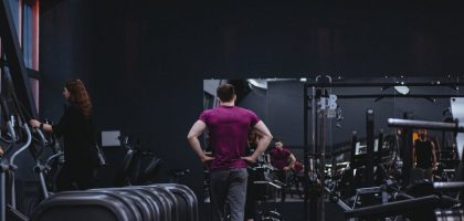 Man in a gym with fitness equipment, highlighting a healthy lifestyle.
