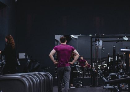Man in a gym with fitness equipment, highlighting a healthy lifestyle.